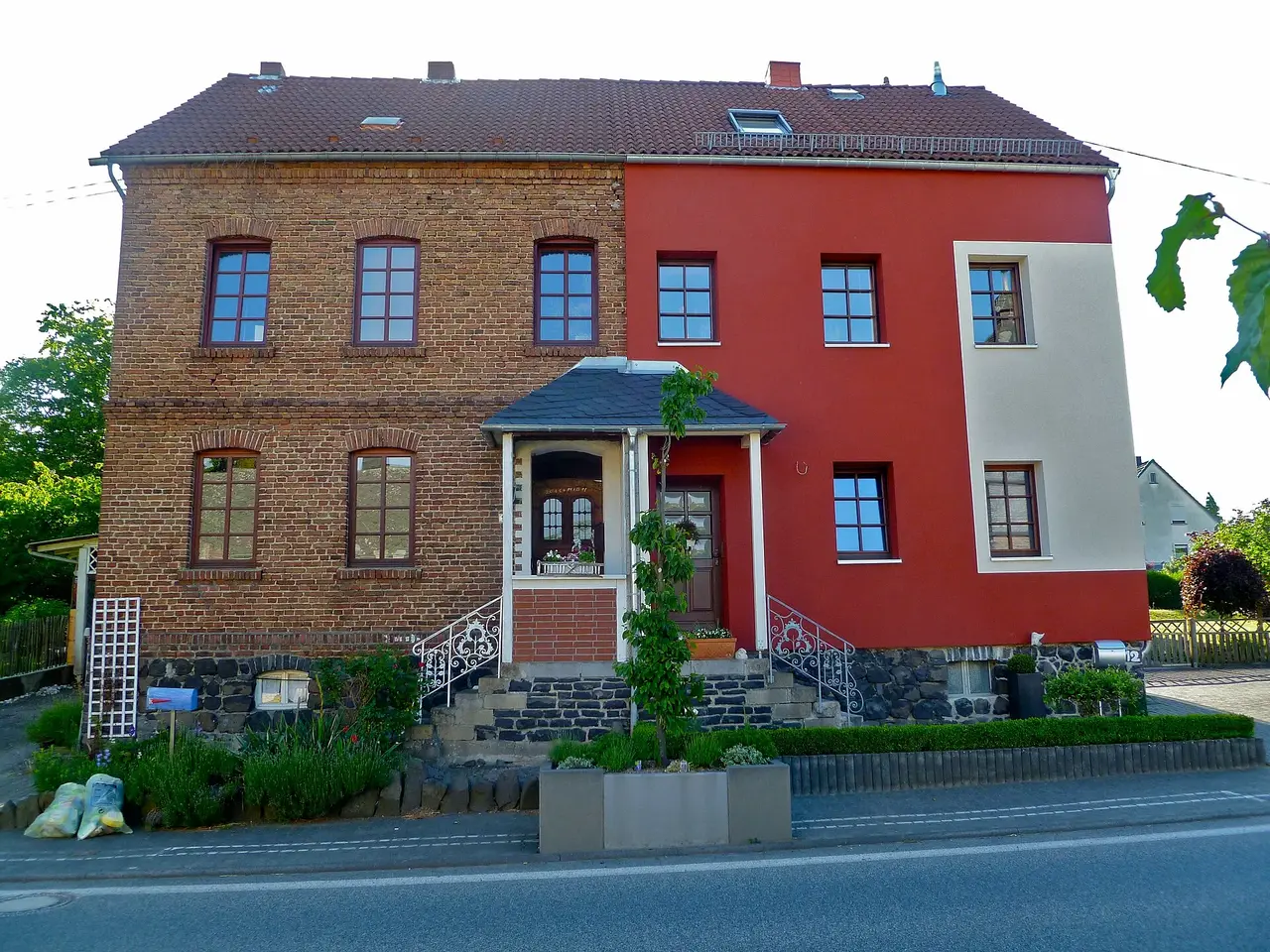 Régi téglaház homlokzata, félig már hőszigetelve és vakolva